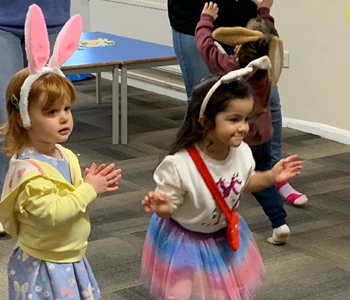 Children wearing bunny ears dancing