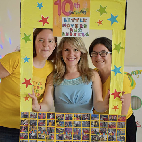 Franchisor and franchisees holding a frame.