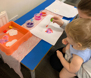 Parent and children painting on a craft table