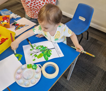 Child painting at a craft table