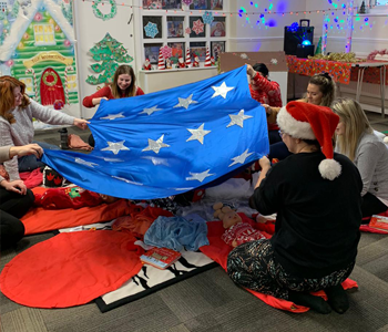 Children and adults sitting on play mat